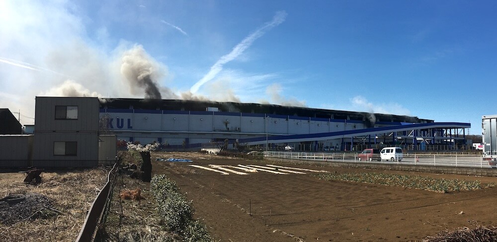 激しく煙が上がる物流センター-2